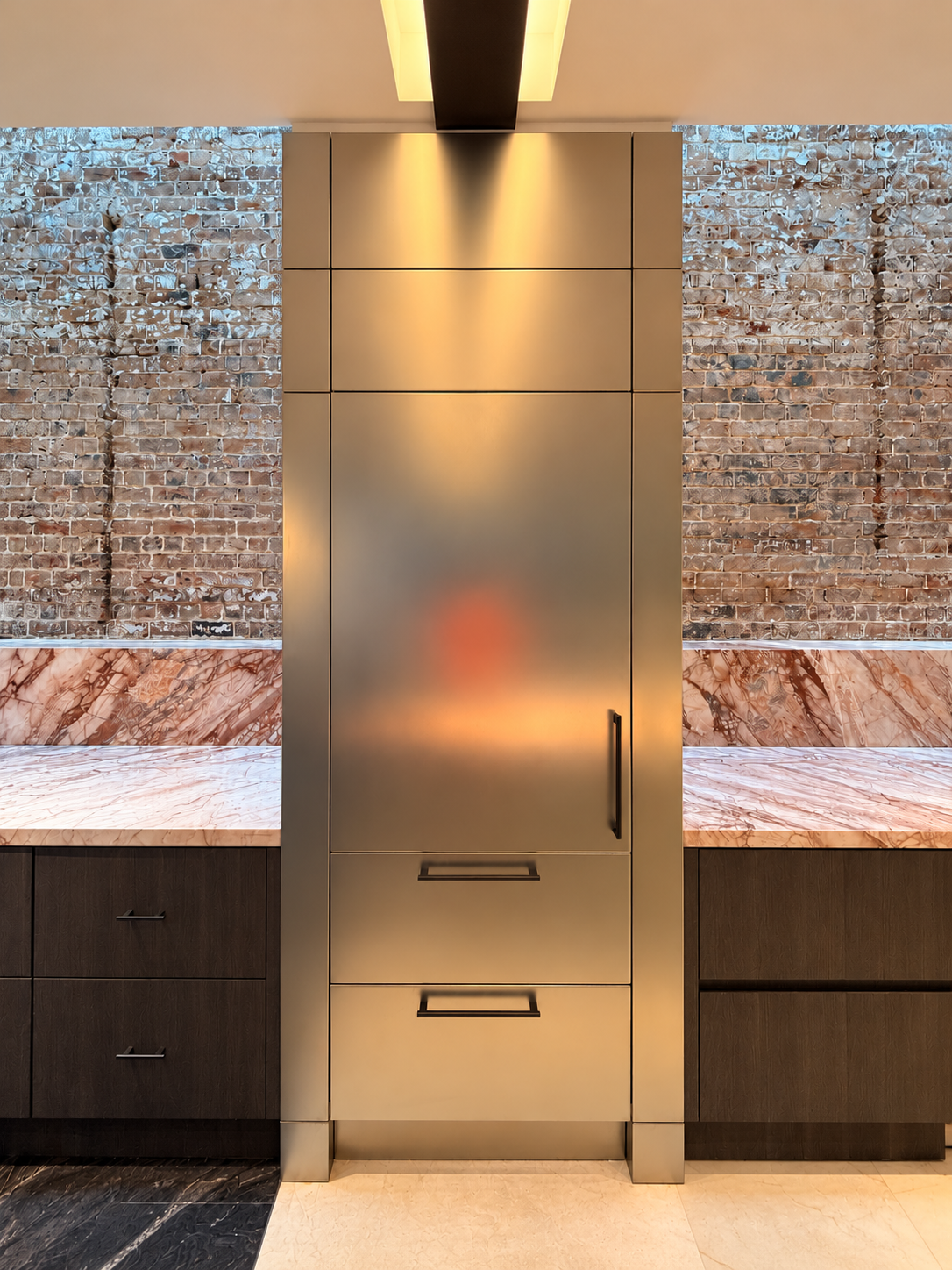 Metallic kitchen cabinetry with brick and pink stone finishes