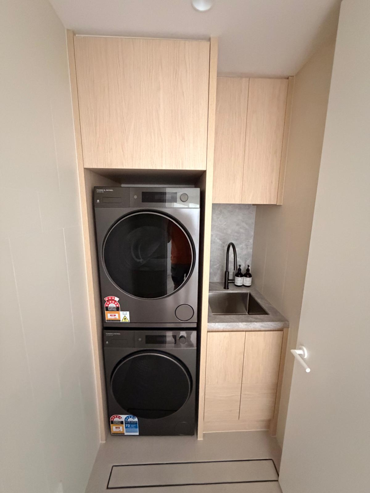 Laundry joinery around stacked appliances and sink